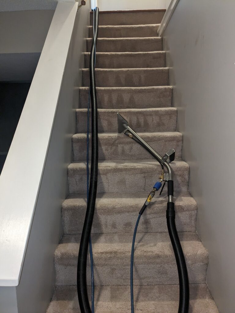 A staircase with some wires hanging from the side.